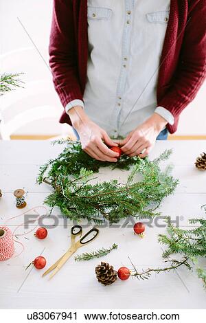 Woman decorating Christmas wreath View Large Photo Image Stock Image - Woman decorating Christmas wreath. Fotosearch