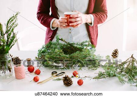 Woman decorating Christmas wreath View Large Photo Image Stock Image - Woman decorating Christmas wreath. Fotosearch
