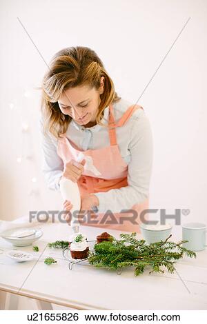 Woman icing chocolate cupcakes with whipped cream View Large Photo Image Stock Photograph - Woman icing chocolate cupcakes with whipped cream. Fotosearch