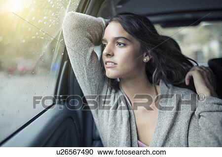 Woman looking out of car window View Large Photo Image Stock Image - Woman looking out of car window. Fotosearch