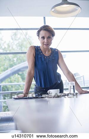 Woman standing at meeting room table View Large Photo Image Stock Image - Woman standing at meeting room table. Fotosearch
