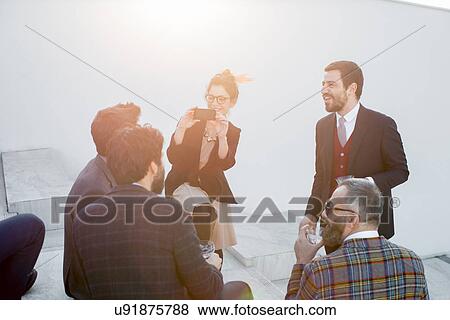 Woman taking a photograph of group of friends at party View Large Photo Image Stock Photo - Woman taking a photograph of group of friends at party. Fotosearch
