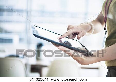 Woman using digital tablet at office View Large Photo Image Stock Image - Woman using digital tablet at office. Fotosearch