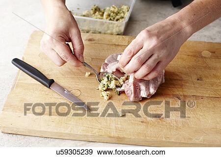 Womans hands stuffing pork steaks on chopping board View Large Photo Image Stock Photo - Womans hands stuffing pork steaks on chopping board. Fotosearch