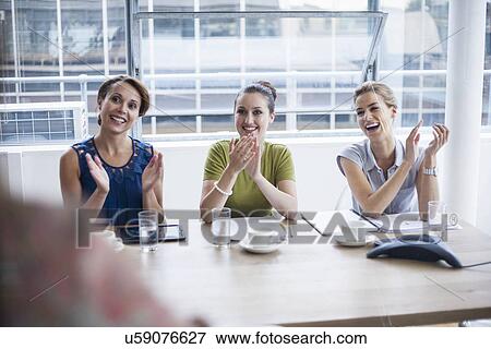 Stock Photo - Women applauding at end of presentation. Fotosearch