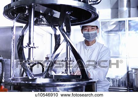 Stock Image - "Worker at e-cigarettes battery factory, Guangdong, China". Fotosearch