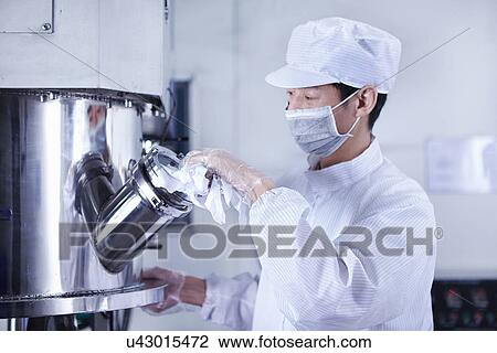 Stock Image - "Worker at e-cigarettes battery factory, Guangdong, China". Fotosearch