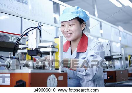 Stock Image - "Worker at e-cigarettes battery factory, Guangdong, China". Fotosearch