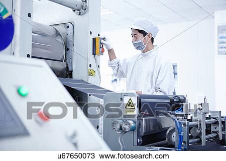 Stock Image - "Worker at e-cigarettes battery factory, Guangdong, China". Fotosearch