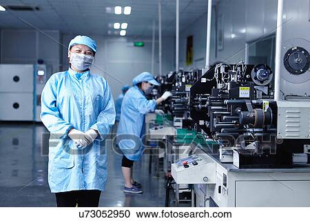 Stock Image - "Worker at e-cigarettes battery factory, Guangdong, China". Fotosearch