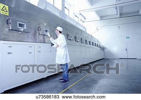 Stock Image - "Worker at e-cigarettes battery factory, Guangdong, China". Fotosearch