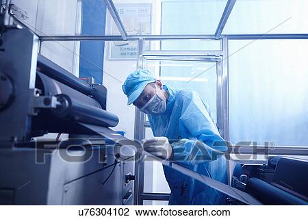 Stock Image - "Worker at e-cigarettes battery factory, Guangdong, China". Fotosearch