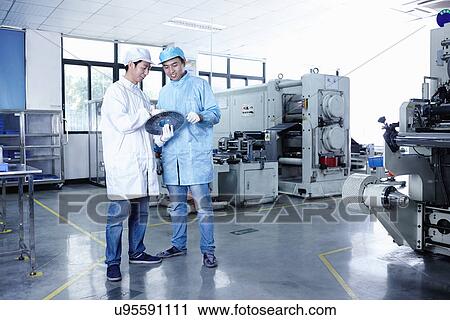 Stock Image - "Worker at e-cigarettes battery factory, Guangdong, China". Fotosearch