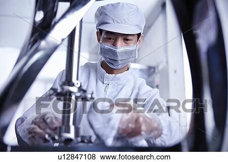 Stock Photo - "Worker at e-cigarettes battery factory, Guangdong, China". Fotosearch