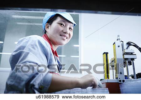 Stock Photo - "Worker at e-cigarettes battery factory, Guangdong, China". Fotosearch
