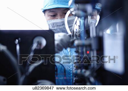 Stock Photo - "Worker at e-cigarettes battery factory, Guangdong, China". Fotosearch