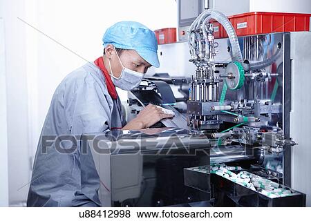 Stock Photo - "Worker at e-cigarettes battery factory, Guangdong, China". Fotosearch