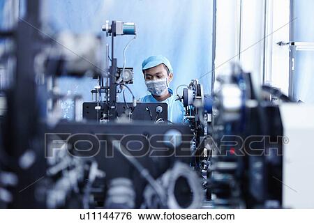 Stock Photograph - "Worker at e-cigarettes battery factory, Guangdong, China". Fotosearch