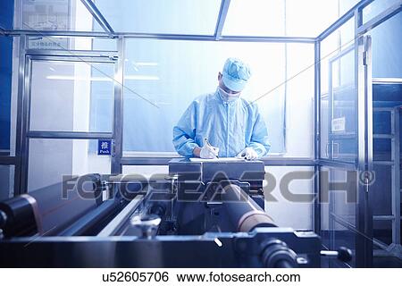 Stock Photograph - "Worker at e-cigarettes battery factory, Guangdong, China". Fotosearch