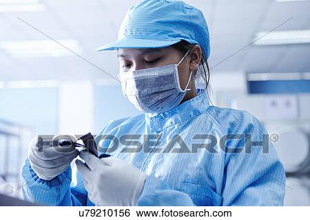 Stock Photograph - "Worker at e-cigarettes battery factory, Guangdong, China". Fotosearch