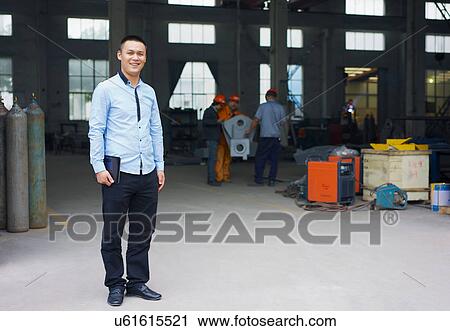 "Worker holding digital tablet in crane manufacturing facility, China" View Large Photo Image Stock Image - "Worker holding digital tablet in crane manufacturing facility, China". Fotosearch