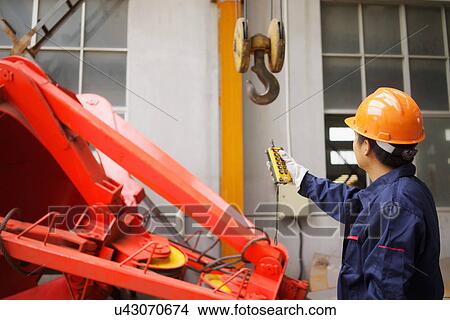 Picture - "Worker using equipment in crane manufacturing facility, China". Fotosearch