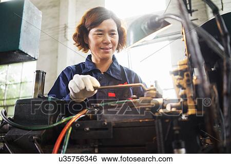 Stock Photograph - "Worker using equipment in crane manufacturing facility, China". Fotosearch