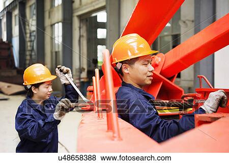 "Workers using equipment in crane manufacturing facility, China" View Large Photo Image Stock Photo - "Workers using equipment in crane manufacturing facility, China". Fotosearch