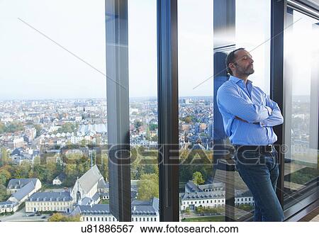 "Worried businessman leaning against office window with Brussels cityscape, Belgium" View Large Photo Image Stock Photo - "Worried businessman leaning against office window with Brussels cityscape, Belgium". Fotosearch