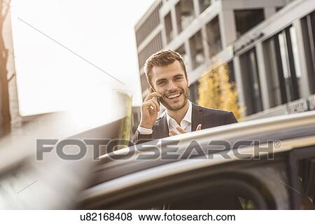 Young businessman chatting on smartphone View Large Photo Image Stock Photo - Young businessman chatting on smartphone. Fotosearch