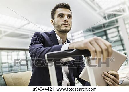 Young businessman in airport departure lounge with digital tablet View Large Photo Image Stock Image - Young businessman in airport departure lounge with digital tablet. Fotosearch