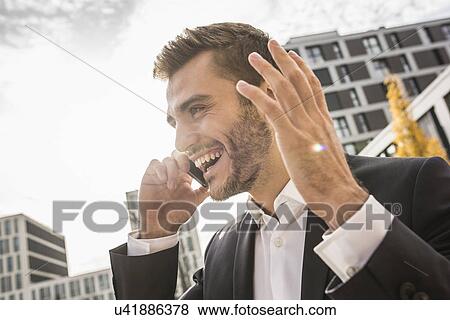 Young businessman on street chatting on smartphone View Large Photo Image Stock Photo - Young businessman on street chatting on smartphone. Fotosearch