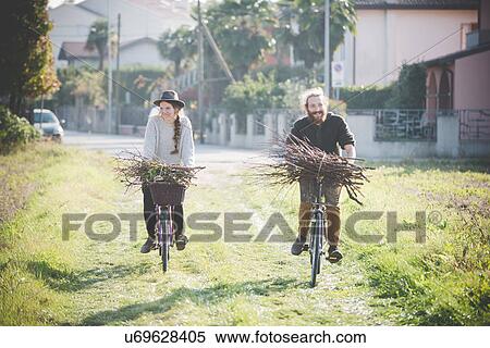 Young couple carrying bunches of sticks on bicycles View Large Photo Image Stock Photography - Young couple carrying bunches of sticks on bicycles. Fotosearch