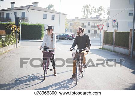 Stock Image - "Young couple cycling on road, Dolo, Venice, ITaly". Fotosearch