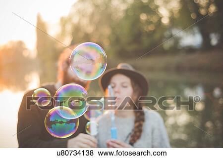 Young couple playing with bubbles View Large Photo Image Stock Photo - Young couple playing with bubbles. Fotosearch