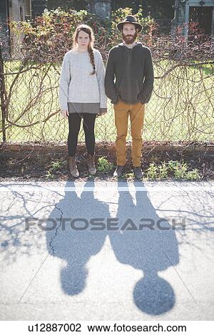 Stock Image - "Young couple side by side, portrait". Fotosearch