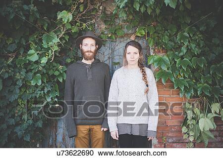 Stock Image - "Young couple side by side, portrait". Fotosearch
