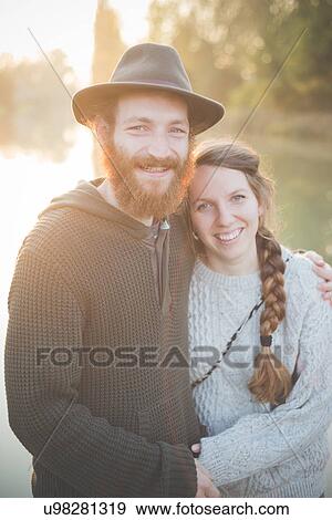"Young couple sitting by river, portrait" View Large Photo Image Stock Photo - "Young couple sitting by river, portrait". Fotosearch
