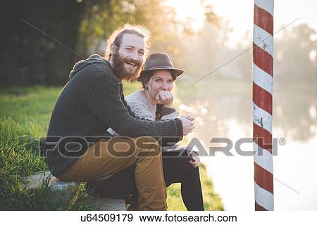 Young couple sitting on steps by river View Large Photo Image Stock Photo - Young couple sitting on steps by river. Fotosearch