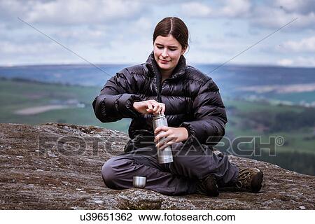 "Young female hiker opening flask on top of Guise Cliff, Pateley Bridge, Nidderdale, Yorkshire Dales" View Large Photo Image Stock Image - "Young female hiker opening flask on top of Guise Cliff, Pateley Bridge, Nidderdale, Yorkshire Dales". Fotosearch