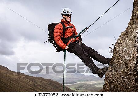"Young male climber abseiling down rock, The Lake District, Cumbria, UK" View Large Photo Image Stock Image - "Young male climber abseiling down rock, The Lake District, Cumbria, UK". Fotosearch