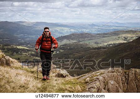 "Young male hiker hiking up mountain, The Lake District, Cumbria, UK" View Large Photo Image Stock Photo - "Young male hiker hiking up mountain, The Lake District, Cumbria, UK". Fotosearch