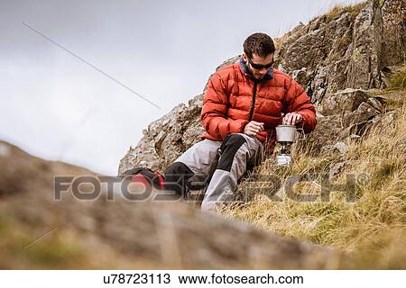 "Young male hiker igniting camping stove, The Lake District, Cumbria, UK" View Large Photo Image Stock Image - "Young male hiker igniting camping stove, The Lake District, Cumbria, UK". Fotosearch