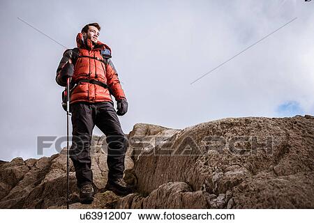 "Young male hiker looking out from rocks, The Lake District, Cumbria, UK" View Large Photo Image Stock Photo - "Young male hiker looking out from rocks, The Lake District, Cumbria, UK". Fotosearch