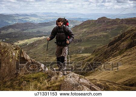 "Young male hiker moving up mountain, The Lake District, Cumbria, UK" View Large Photo Image Stock Image - "Young male hiker moving up mountain, The Lake District, Cumbria, UK". Fotosearch
