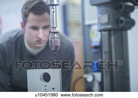 Young male technician checking metal drill machine in workshop View Large Photo Image Stock Image - Young male technician checking metal drill machine in workshop. Fotosearch