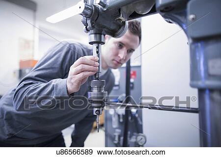 Young male technician checking workshop machinery View Large Photo Image Stock Photo - Young male technician checking workshop machinery. Fotosearch