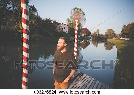 Picture - "Young man by river, Dolo, Venice, Italy". Fotosearch
