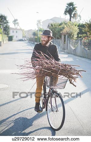 Young man carrying bunch of sticks on bike View Large Photo Image Stock Image - Young man carrying bunch of sticks on bike. Fotosearch