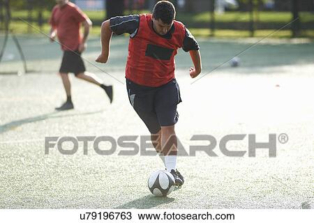 Young man dribbling football View Large Photo Image Stock Image - Young man dribbling football. Fotosearch